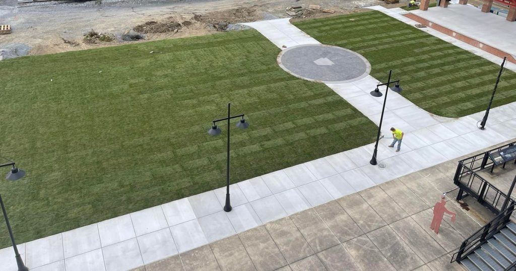 Post-top light fixtures installed along a new concrete walkway at a Blair County project site.